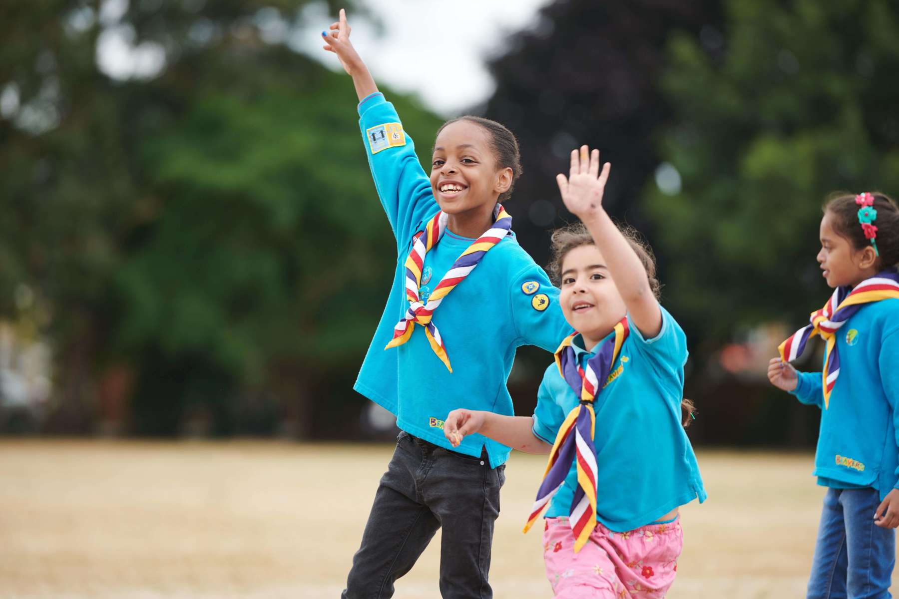 Children dressed in Beavers uniforms waving