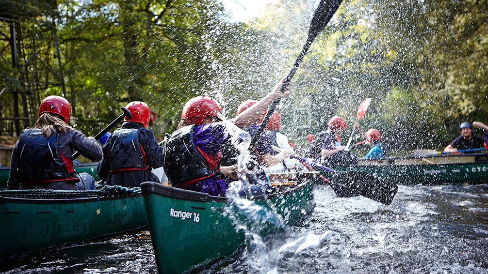 Young people going down a river in a kayak