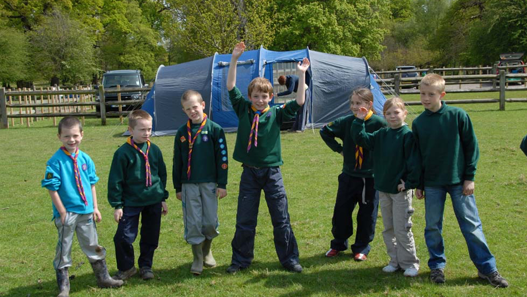 Children dressed in Cubs uniforms outside a tent