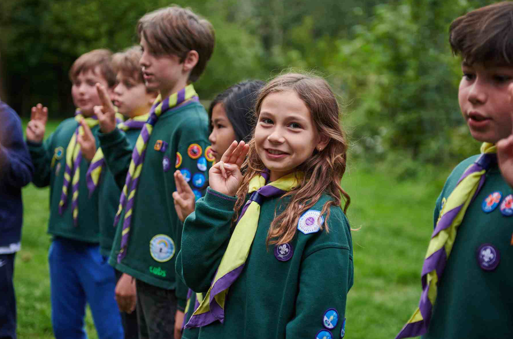 Children dressed in Cubs uniforms doing the cub scout promise