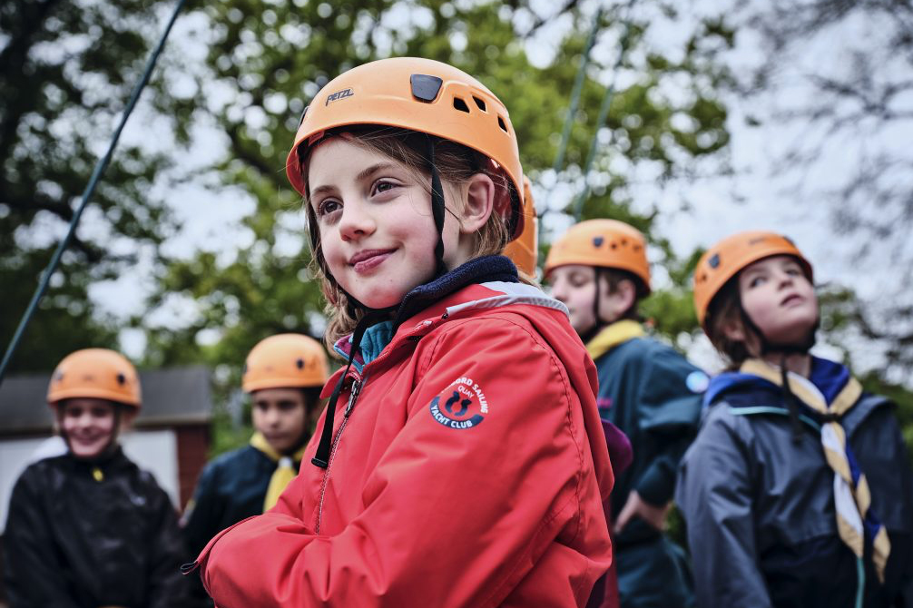 A proud girl scout wearing a safety helmet with arms crossed
